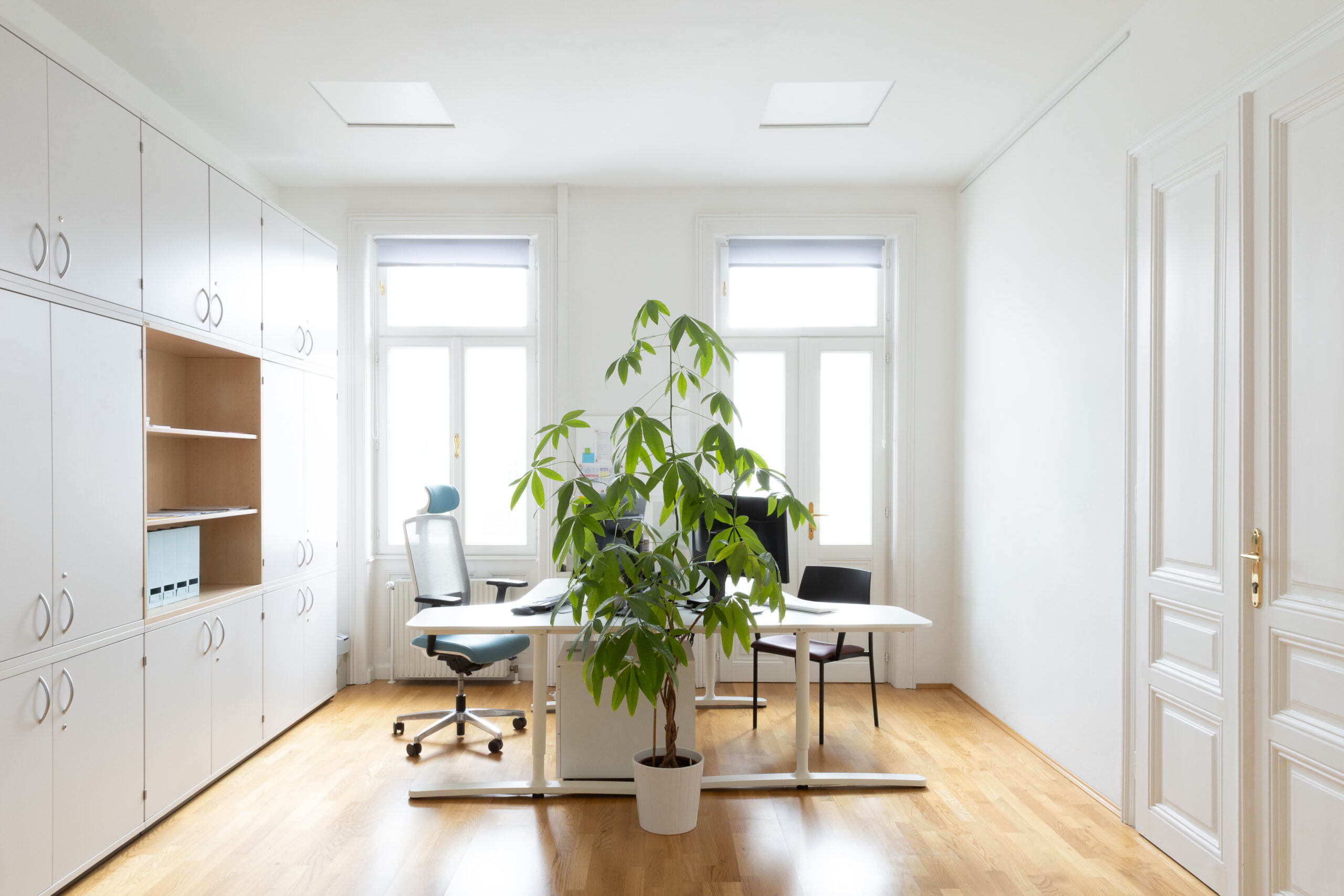 Helle Büroräumlichkeiten für zwei Arbeitsplätze. Bürosessel, Schreibtische und Wandschrank